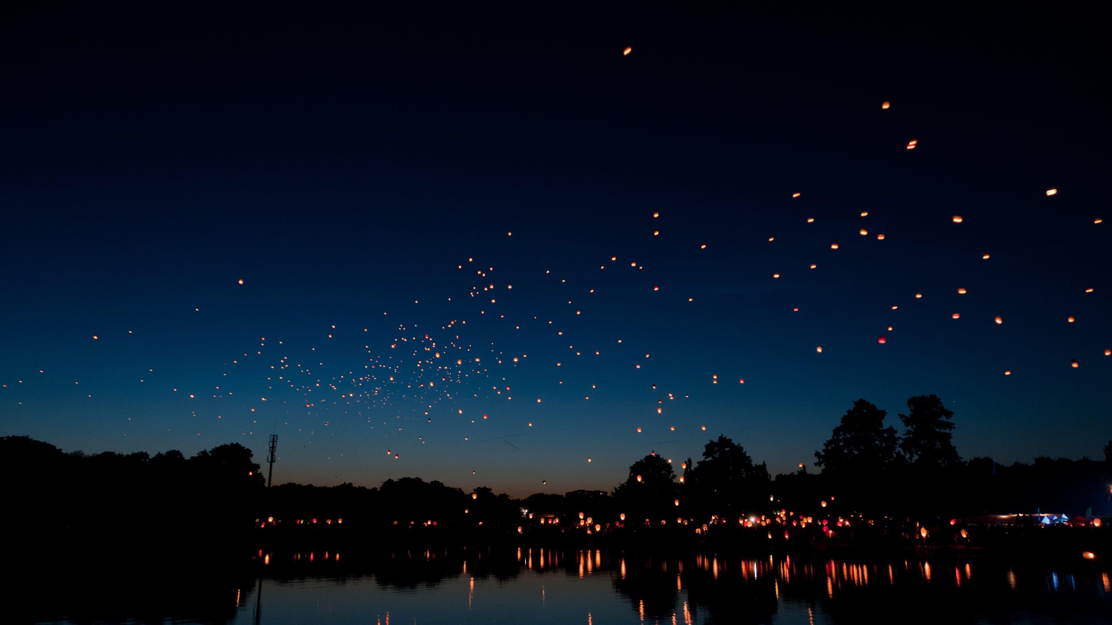 Glowing Lanterns Over Dark Water - 4K Background Glowing Lanterns Over Dark Water - Nighttime Photography 4K Wallpaper (3840x2160)