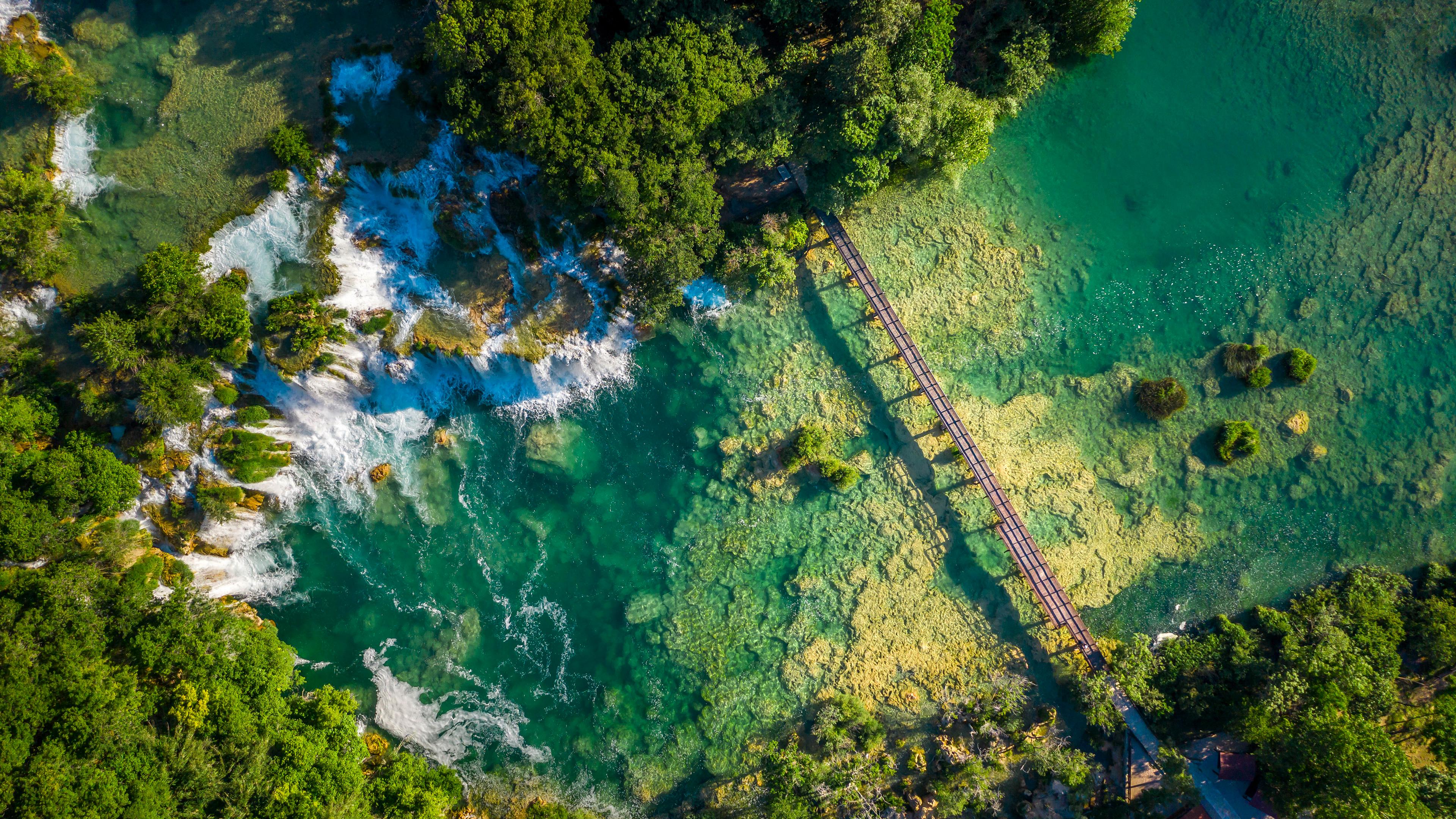 Turquoise Waterfalls and Wooden Bridge - 4K Background Turquoise Waterfalls and Wooden Bridge - Aerial Photography 4K Wallpaper (3840x2160)
